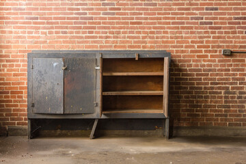 Empty cabinet left forgotten in an abandoned factory with red brick wall