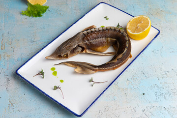 smoked fish sturgeon in a plate with lemon