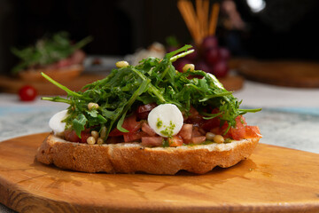 bruschetta with tomatoes, peppers and rucola on a board