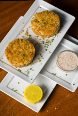 Crab cake served w/ spicy rémoulade sauce on top of a mixed green salad. Jumbo crab meat mixed w/ garlic, onions, spices & fried in butter. Classic American restaurant appetizer.