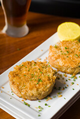 Crab cake served w/ spicy rémoulade sauce on top of a mixed green salad. Jumbo crab meat mixed w/ garlic, onions, spices & fried in butter. Classic American restaurant appetizer.