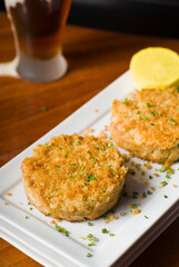 Crab cake served w/ spicy rémoulade sauce on top of a mixed green salad. Jumbo crab meat mixed w/ garlic, onions, spices & fried in butter. Classic American restaurant appetizer.