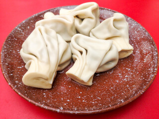 Boiled khinkali on a red table