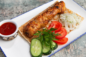 chicken skewers in a plate with fresh vegetables