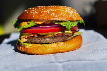 burger with fried meat and tomatoes on the table