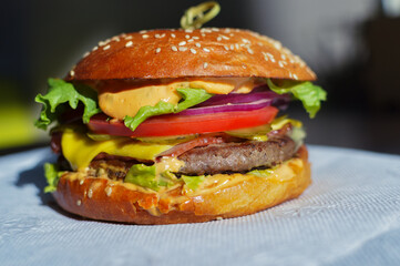 burger with fried meat and tomatoes on the table