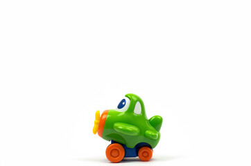 Small green toy airplane with eyes. Children's toy on a white background.