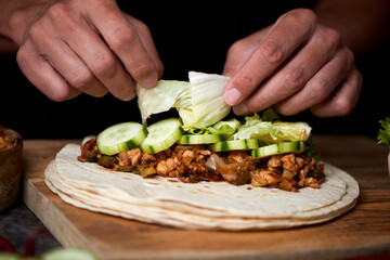 man preparing a durum or a burrito