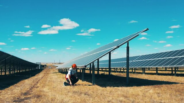 Male specialist is repairing solar panels in the field Energy saving, energy efficiency, renewable energy concept.