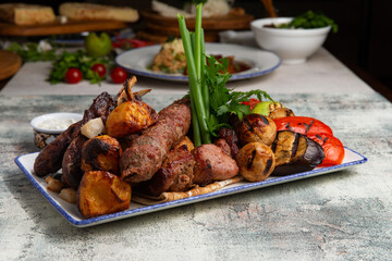 mix of meat, baked vegetables and greens in a plate