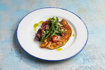 omelet with beef slices and arugula on a plate