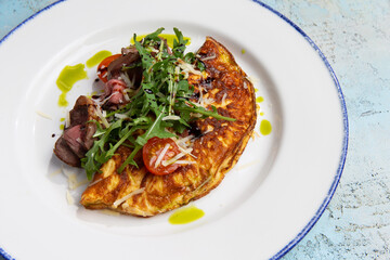 omelet with beef slices and arugula on a plate
