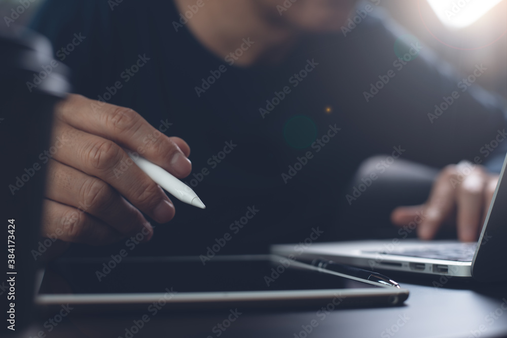 Poster man hand with stylus pen working on digital tablet and surfing internet on laptop computer online wo