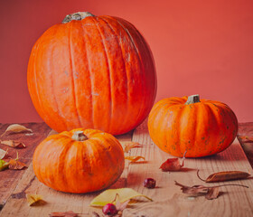 pumpkin and autumn leaves on wooden table