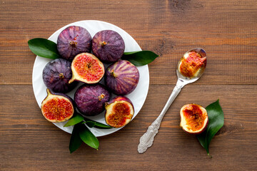Fresh figs in on a plate with green leaves. Top view