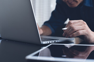 man, surfing the internet online working on laptop computer from home office