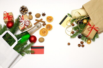 Naklejka na ściany i meble Christmas shopping concept. Hand with a credit card, a bag of groceries, champagne and gifts on a white background. Online shopping, credit card paymen
