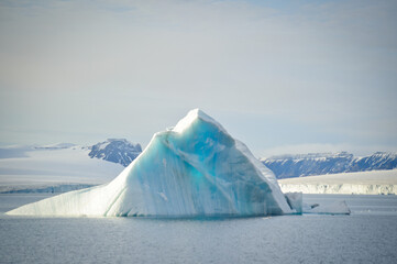 An icy white iceberg floats in the sea in the Arctic on Svalbard