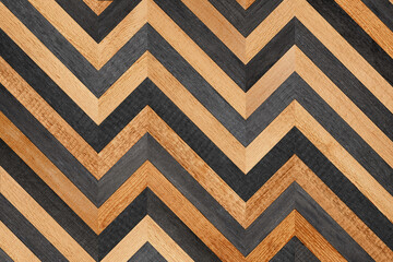 Wooden background. Rough parquet floor with chevron pattern. Wooden planks texture. 