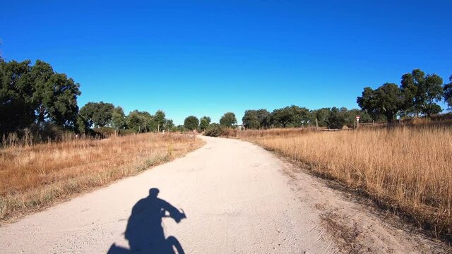 dolly move forward - shadow of a touring cyclist riding on a rural dirt road next to Flor da Rosa village, municipality of Crato, Portalegre district, Alentejo, Portugal