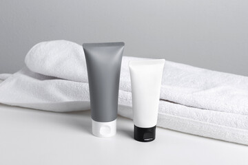 Mock up cosmetics. Bottle, tube, jar of cream or lotion with white towel on a white marble background. Organic cosmetic. Treatment spa beauty skincare healthcare. Brand commercial. Product