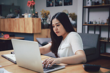 Young asian woman in smart casual wear working in home office. Social distance practice prevent coronavirus COVID-19.