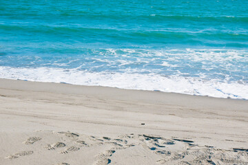 波打ち際の海と砂浜の足跡