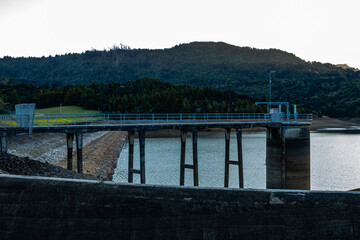 Fototapeta premium Sun setting over the Waitakrie Dam. auckland, New Zealand