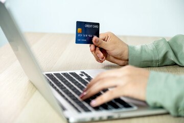 Businesswoman hand holding and use credit card to online shopping from home with laptop, payment e-commerce, internet banking, spending money for next holidays
