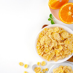 Top view of corn flakes bowl with milk on white background.