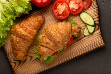 Vegan croissants sandwiches on wooden board top view, healthy vegetarian food concept