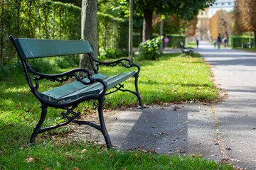 Park bench on a sunny autumn day in the Augarten park in Vienna, Austria. 