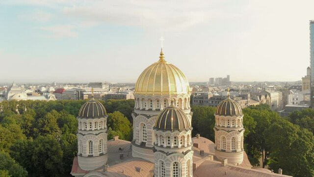 Sensational aerial view of Nativity of Christ Cathedral, majestic golden dome, Riga, Latvia, drone circle shot, day