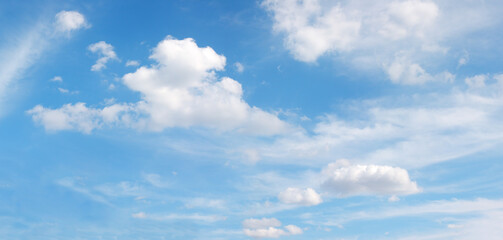white fluffy flying clouds on blue panoramic sky, heaven background in high resolution