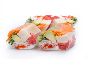 Rolls with fish various vegetables are spread out on isolated background