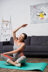 joyful pregnant woman exercising on fitness mat at home
