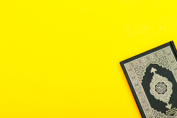 Fototapeta premium closed Quran ( mean holy book of muslim) with Arabic calligraphy text on yellow