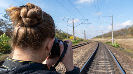 Woman photographing railway tracks