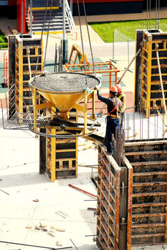 builder worker with tube from truck mounted concrete pump pouring cement into formwork reinforcement