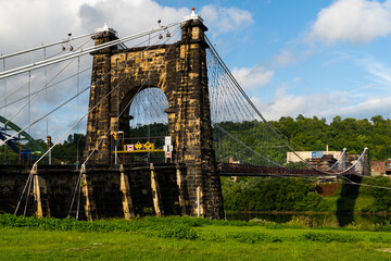 This is a side profile showing the masonry tower of the historic Wheeling Suspension Bridge that carries the National Road over the Ohio River in Wheeling, West Virginia.