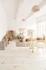 Large spacious room with a trendy loft design of sitting area. huge windows and stylish wicker light furniture inside. an abundance of ethnic decor