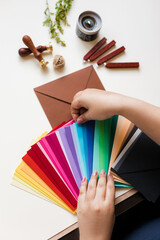 a bundle of colored envelopes in his hands on the table