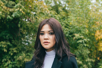 Fototapeta premium Young asian girl in front of the autumn trees