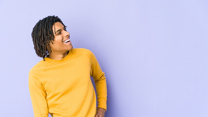 Young black man wearing rasta hairstyle relaxed and happy laughing, neck stretched showing teeth.