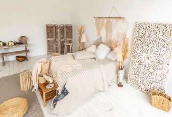 Large spacious room with a trendy loft design of sitting area. huge windows and stylish wicker light furniture inside. an abundance of ethnic decor