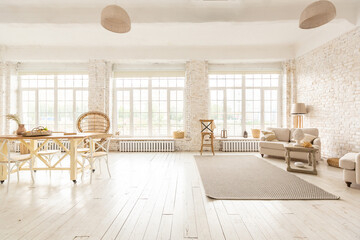 Large spacious room with a trendy loft design of sitting area. huge windows and stylish wicker light furniture inside. an abundance of ethnic decor