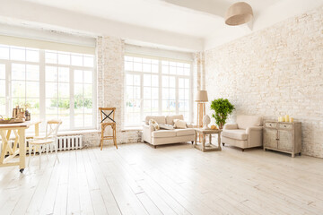Large spacious room with a trendy loft design of sitting area. huge windows and stylish wicker light furniture inside. an abundance of ethnic decor