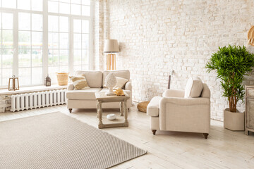 Large spacious room with a trendy loft design of sitting area. huge windows and stylish wicker light furniture inside. an abundance of ethnic decor