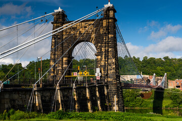 Obraz premium This is a side profile showing the masonry tower of the historic Wheeling Suspension Bridge that carries the National Road over the Ohio River in Wheeling, West Virginia.