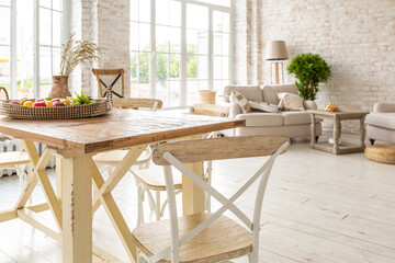 Large spacious room with a trendy loft design of sitting area. huge windows and stylish wicker light furniture inside. an abundance of ethnic decor